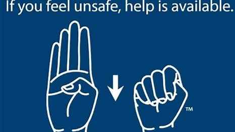 Face your palm toward the person you want to alert. Tuck your thumb into your palm. Fold your fingers down over the thumb, trapping it in your fist.