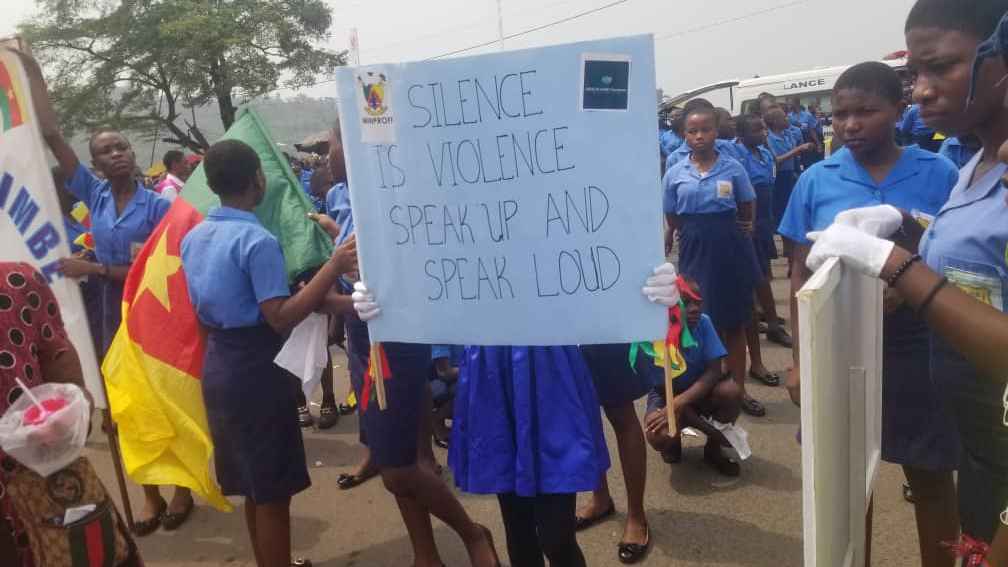 Photo of students carrying educational messages on GBV, at the Limbe grand stand stand. 