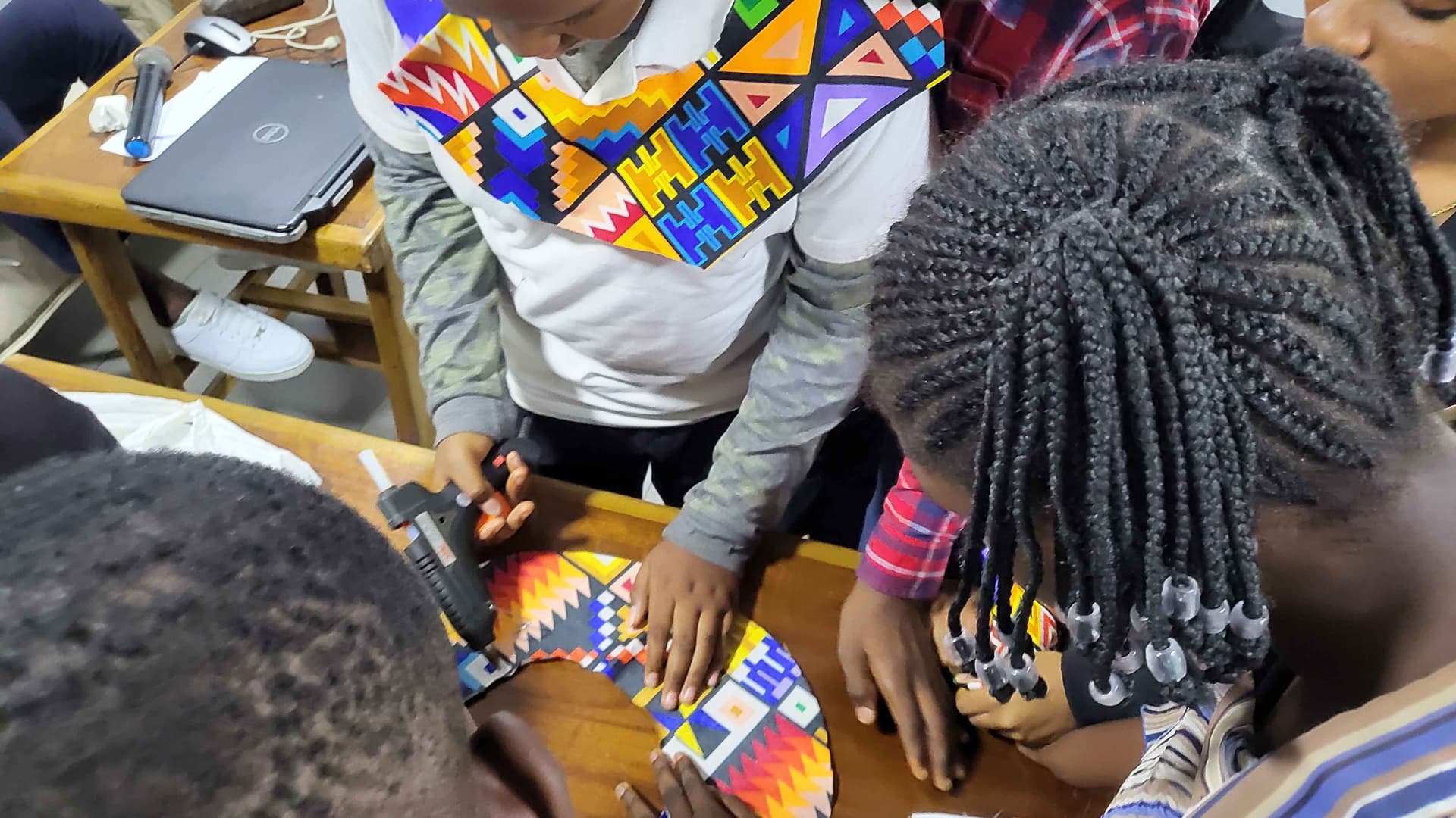 teenagers using old cloths to make handfan